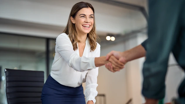 Håndtrykk mellom kunde og rådgiver – personlig service og oppfølging ved firmareiser fra et reisebyrå for bedrifter, ikke en plattform.